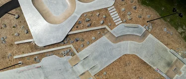 Aerial drone photograph of the Motutawa Skatepark in New Zealand, showing the completed concrete bowl, ramps, rails and path network from above. Photo credit: Convic.