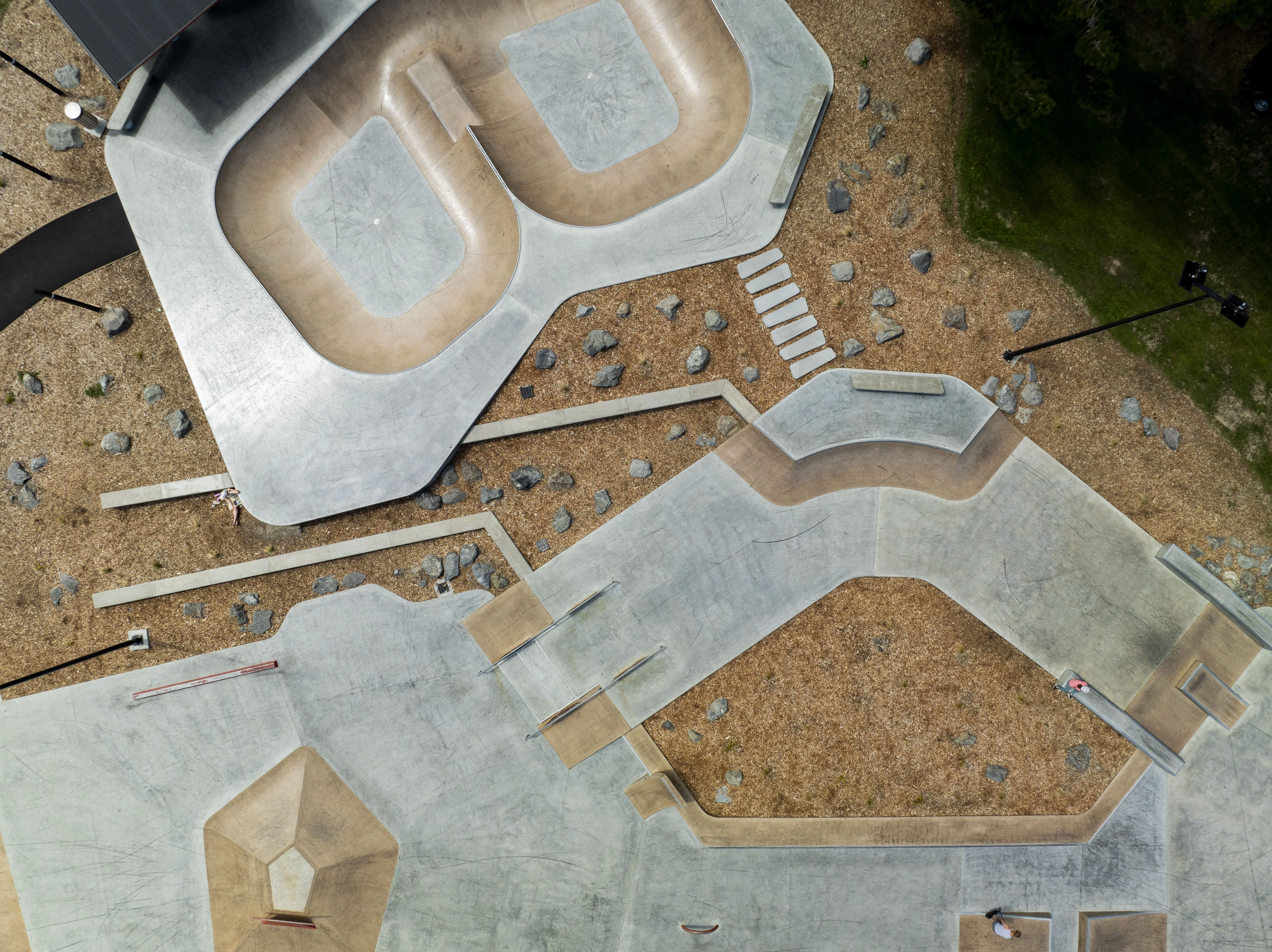 Aerial drone photograph of the Motutawa Skatepark in New Zealand, showing the completed concrete bowl, ramps, rails and path network from above. Photo credit: Convic.